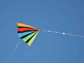 colored kite flying against blue sky