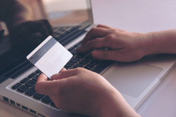 woman hand holding credit card and using laptop making online payment online, online shopping