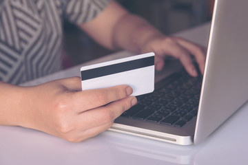 woman hand holding credit card and using laptop making online payment online, online shopping