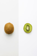 Obraz premium Fresh kiwi whole fruit and slice on grey white background