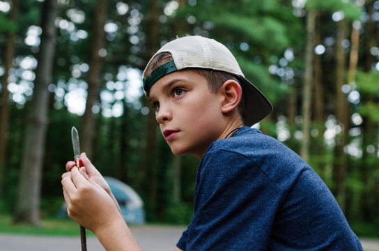 A Boy Sharpening a Stick