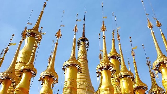 Ornate golden hti umbrellas with ringing bells decorate the medieval pagodas of Inn Thein Buddha Image Shrine, located in the same named village on Inle Lake, Myanmar. 