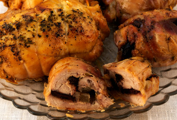 Cut across a meatloaf with prunes on the background of whole rolls with baked crust.