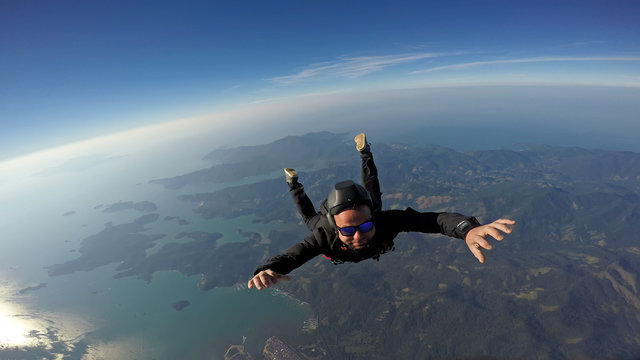 Skydiver jump over the sea and mountains