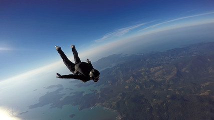 Skydiver jump over the sea and mountains