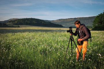 Photographer takes a pictures of a field with chamomiles