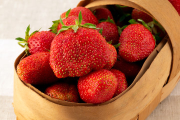 Large strawberry berries, laid in a wicker basket made of bast.