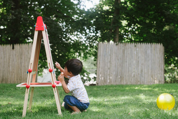 Little kid drawing on chalkboard