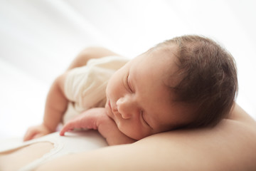 Sleeping newborn baby on her mother's chest