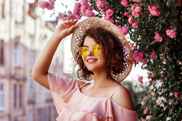 Outdoor close up portrait of young beautiful happy smiling curly girl wearing stylish yellow...