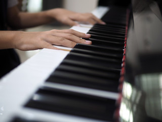 Fototapeta na wymiar Close up of child hand on piano keys playing