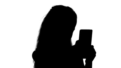 Silhouette Young girl looking into the camera smiling taking selfie track matte
