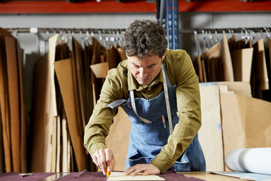 Worker Using Cardboard Paper And Chalk For Marking On Fabric