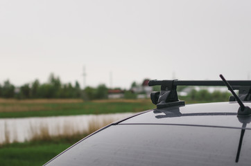 Gray car on the river lake shore in the rainy day. To drive away from the city.