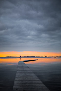 beautiful dawn with a wooden dock and a sailing boat © vorkaPICTURE