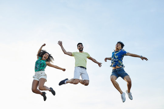 Happy friends jumping over sky.