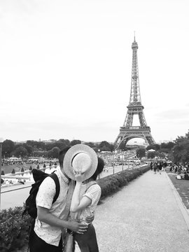 Couple kissing in front of Eiffel Tower in Paris