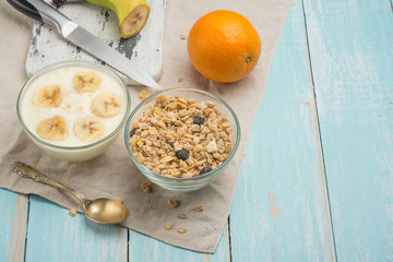 Healthy breakfast. Fresh granola, muesli with yoghurt and fruit on a wooden background. View from above.
