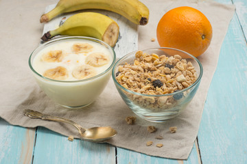 Healthy breakfast. Fresh granola, muesli with yoghurt and fruit on a wooden background. View from above.
