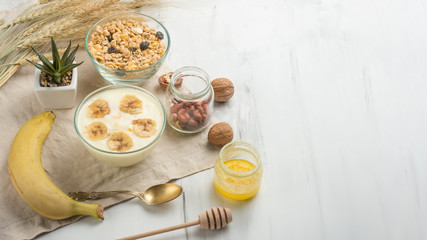 Healthy breakfast. Fresh granola, muesli with yoghurt and fruit on the background of marble. View from above. Copy space.