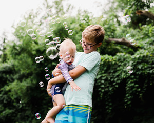 brothers play with bubbles on a summer evening