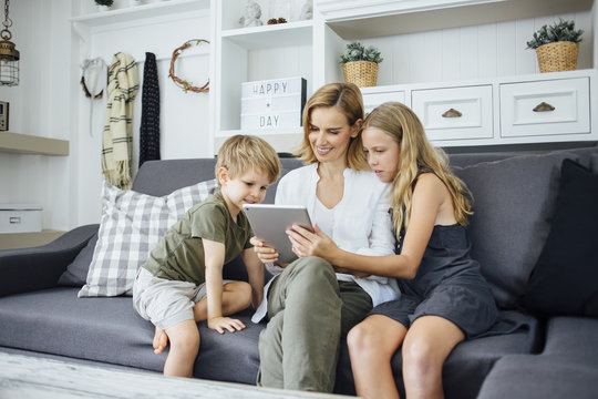 Woman using tablet with kids