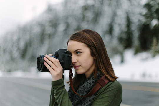 Woman Taking Picture of Winter Landscape