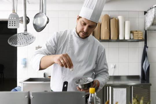 Cook seasoning food in restaurant