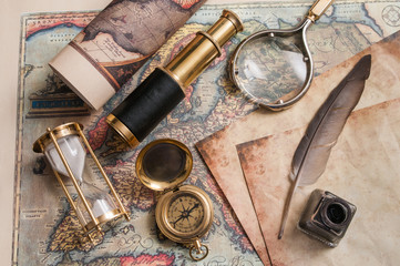 Quill pen and old papers on an old map with vintage items