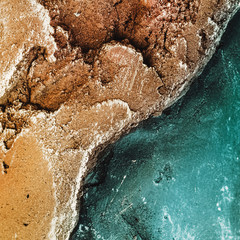 a rock. stone texture. two colors. a shade of gold and sea. texture. square