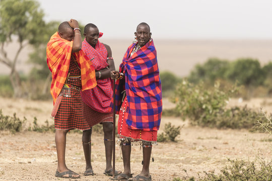 Three Maasai men talking to each other