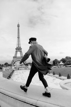 stylish woman having fun in front of the eiffel tower in black and white