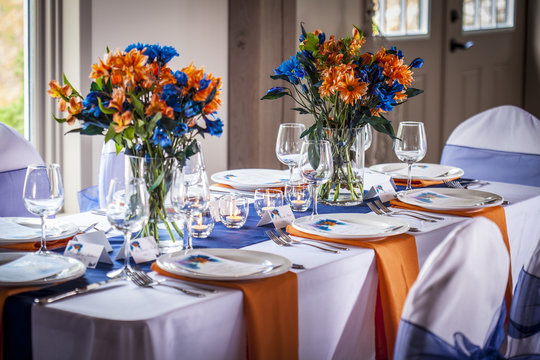 Set table with white, Orange and Blue Linen