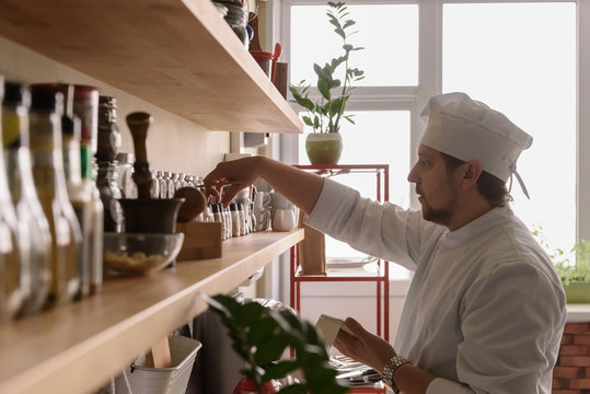 Cook picking spices from shelf
