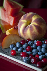 Peaches, Watermelon, Blueberries, Cranberries on slate