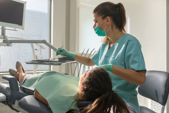 Female orthodontist curing her patient in orthodontic office