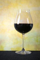 Glass of Red White in Front of Yellow Painted Back Ground