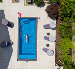 junge Frau liegt im Pool Drohne