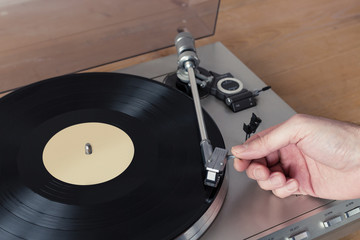 Hand Placing Stylus of Record Player to a Spinning Vinyl