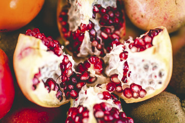 Close Up Shot of a Split Pomegranate on Top of Fruits