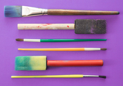 Children's Paint Brushes on a Purple Background