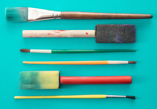 Children's Paint Brushes on a Teal Background