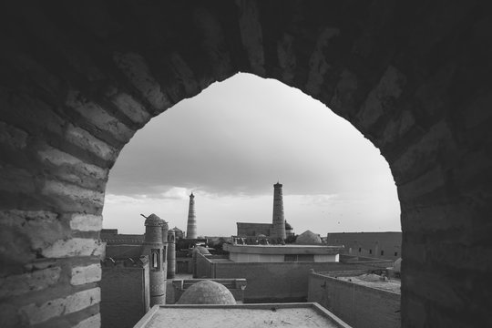 oldtown of khiva seen through an arch, black and white - uzbekistan