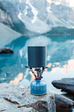 Boiling water with backpacking stove at mountain lake.