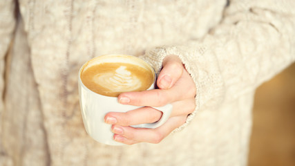 Girl holding a cup of coffee or hot chocolate or chai tea latte. Quiet hygge time concept