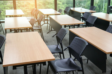 Table in a seminar room arranged in lined with chairs.