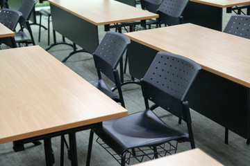 Table in a seminar room arranged in lined with chairs.