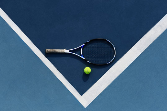 Tennis ball and racket on corner of court