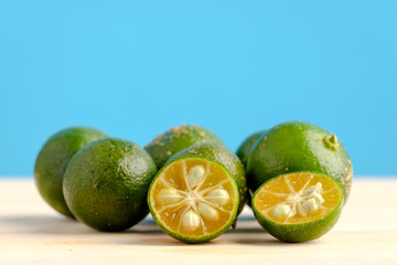 Calamansi on wooden table and blue background