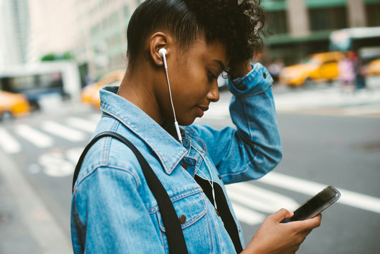 Young Woman Playing Music On Cell Phone